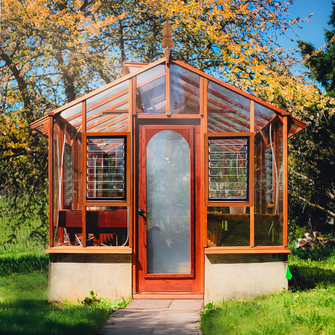 Wooden Artisan greenhouse with glass panels in a garden setting