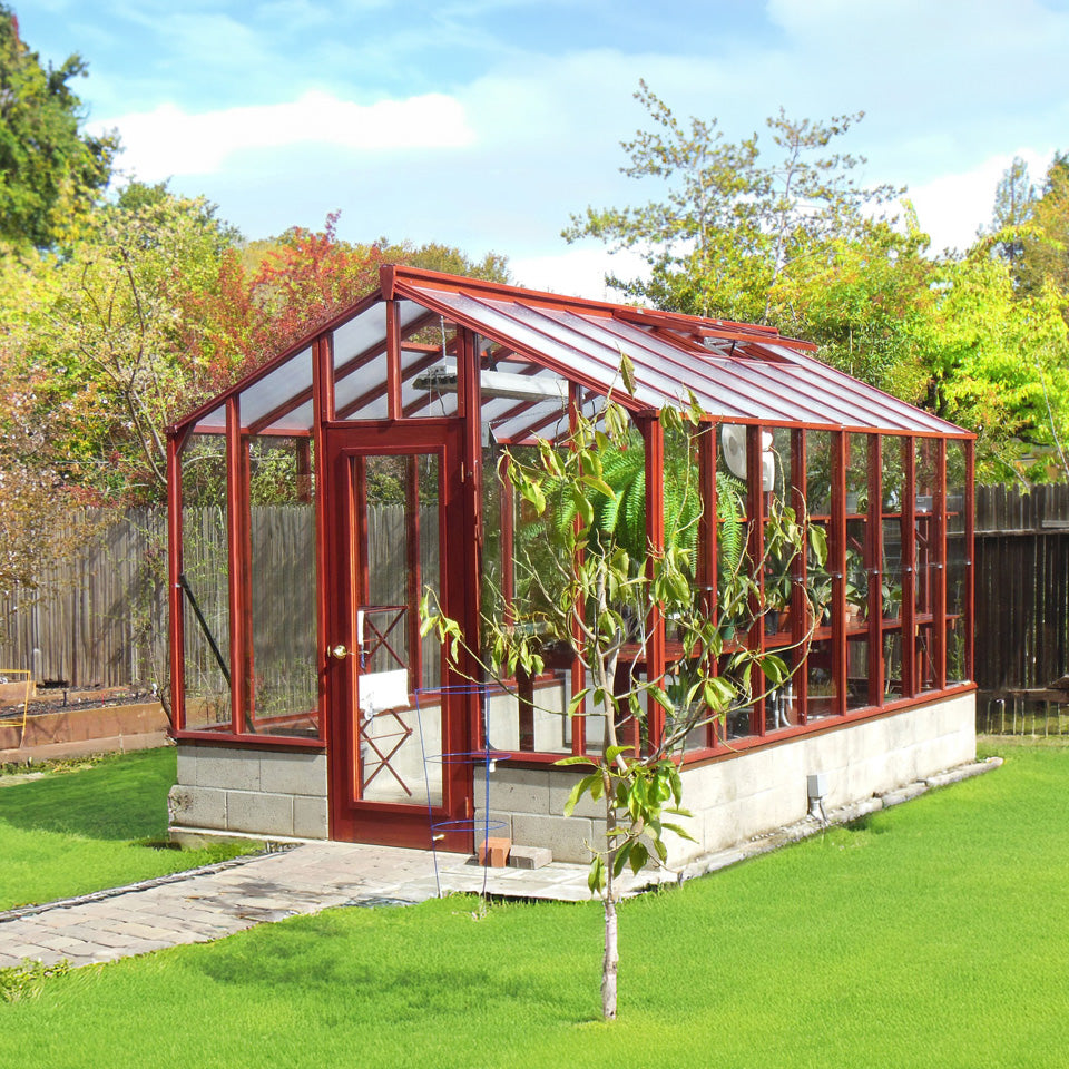 Glass Artisan greenhouse with redwood frame in a garden setting