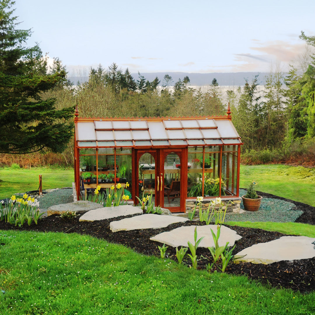 Wooden Nantucket greenhouse in a Washington state garden with greenery and flowers
