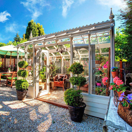 Nantucket greenhouse with plants and furniture in a garden setting