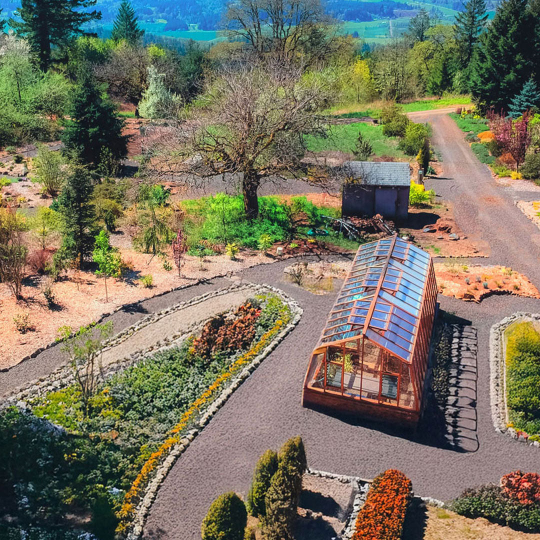 Glass house or greenhouse in a garden setting with trees and pathways