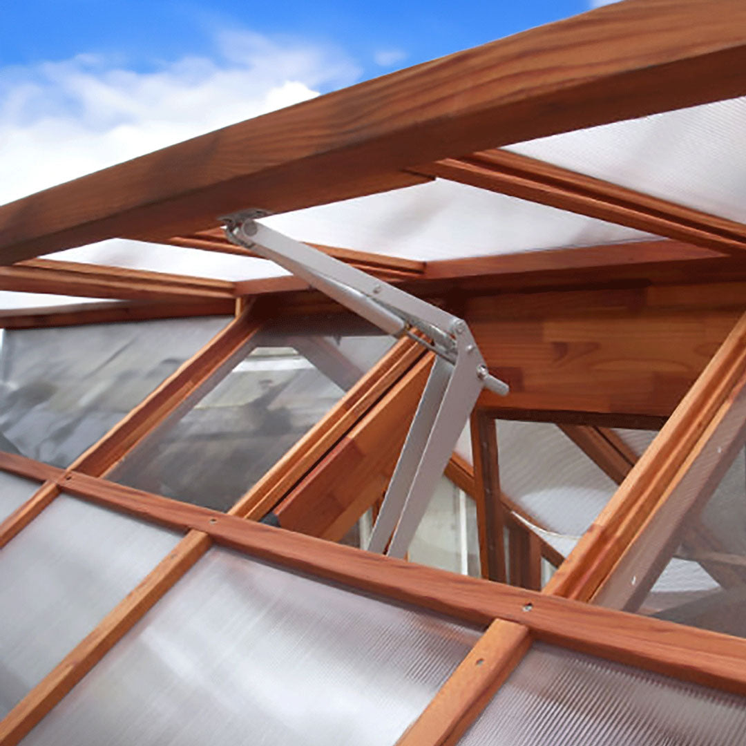 Wooden roof structure with transparent panels against a blue sky