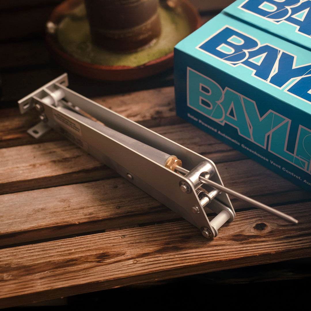 Metal spring mechanism on a wooden surface with a blue 'Baylor' box in the background.
