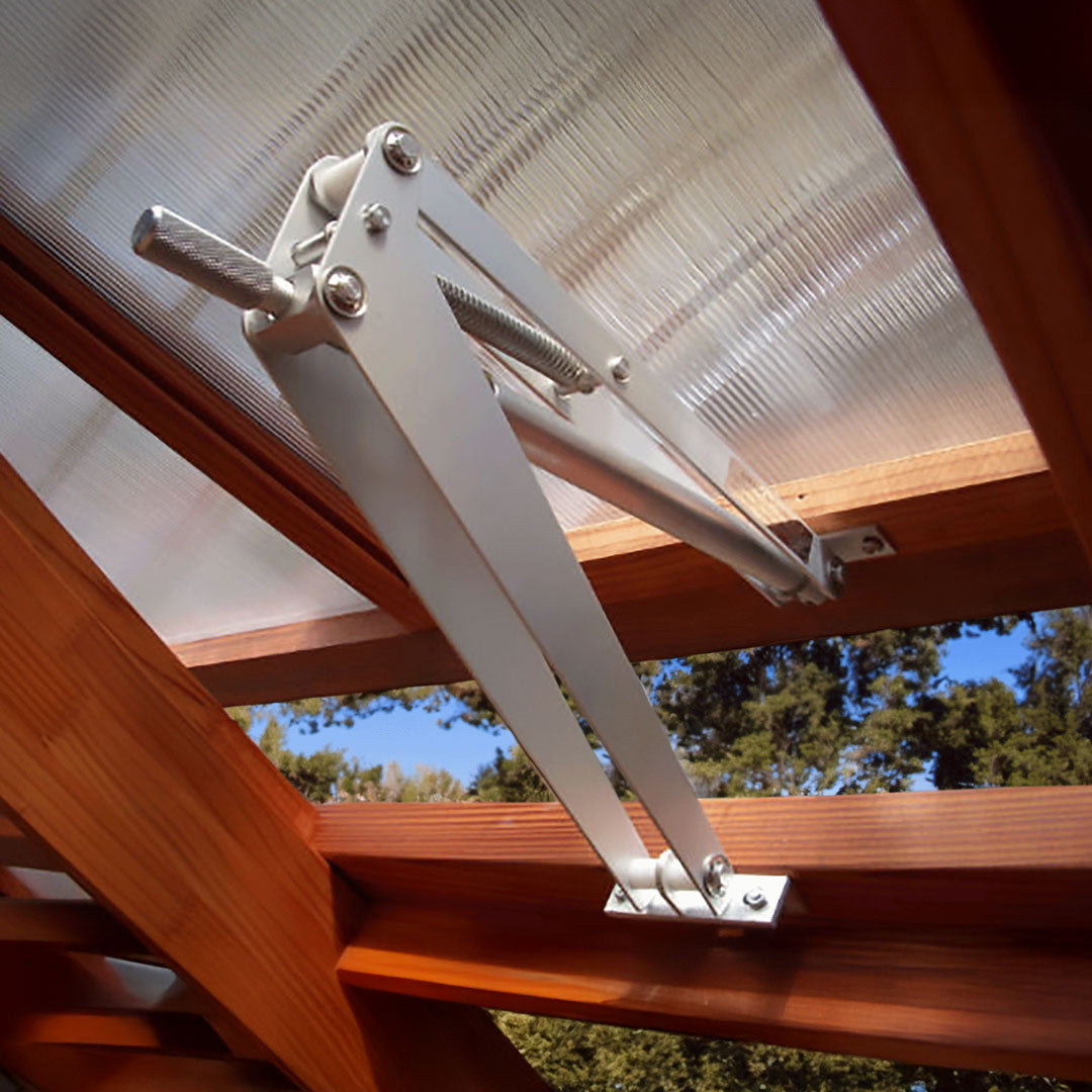 Metal patio door opener attached to a glass door with wooden frame, outdoors.