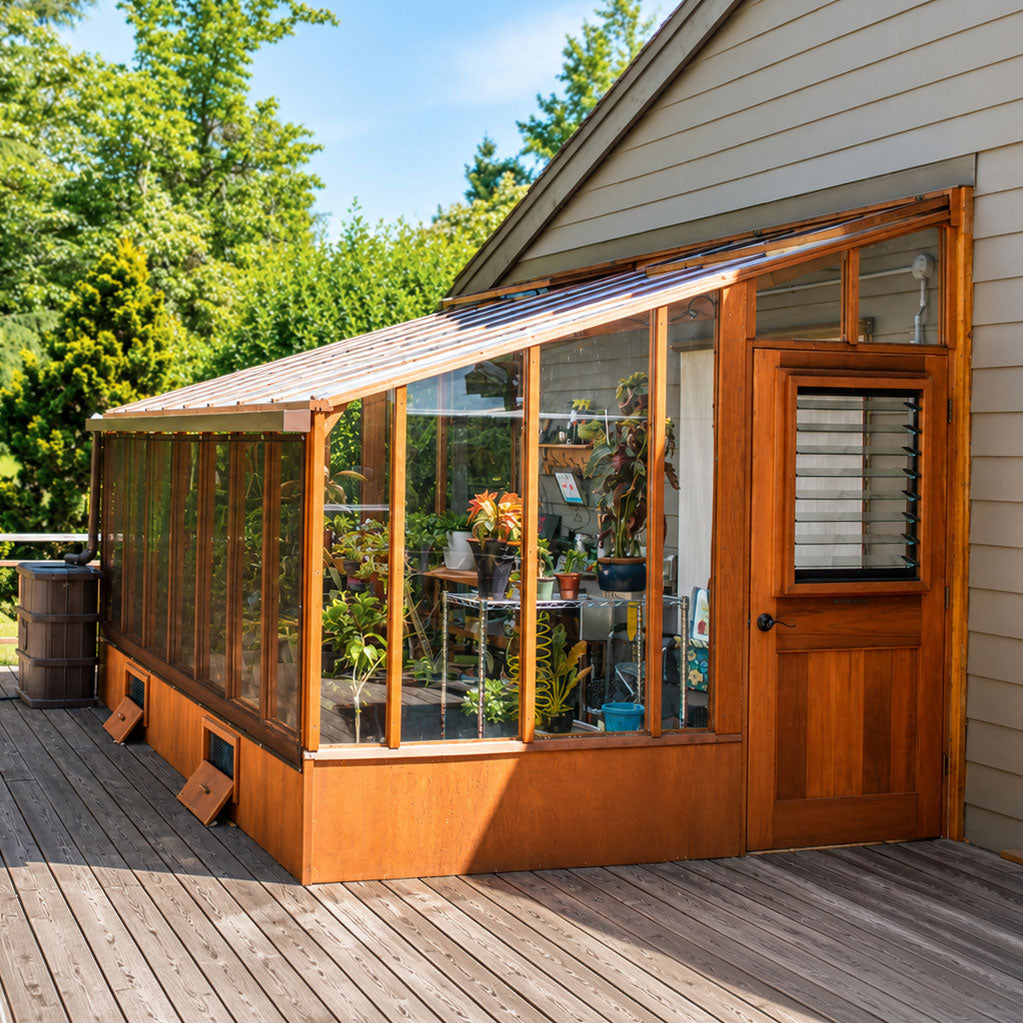 Sunlight illuminates a handcrafted redwood greenhouse filled with plants and showcasing wood grain.