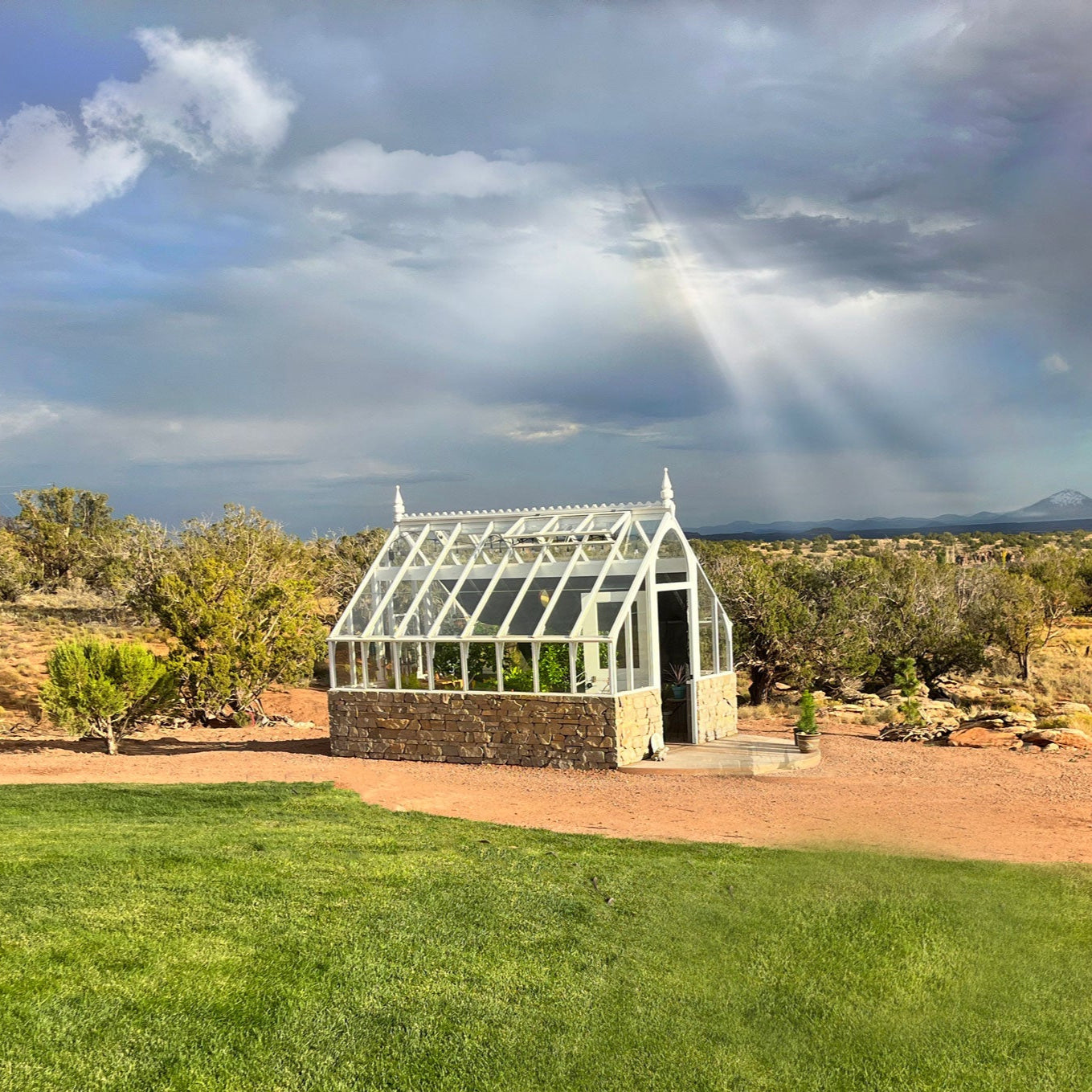 Tudor Greenhouse with masonry base and raised deck overlooking garden valley.