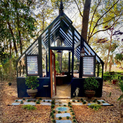 Tudor Greenhouse with black ridge accents and frosted glass in fall setting.