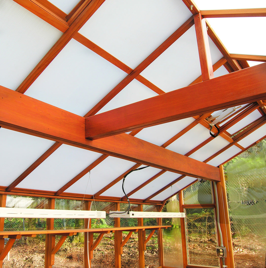 Wooden beams and transparent panels of a greenhouse structure.